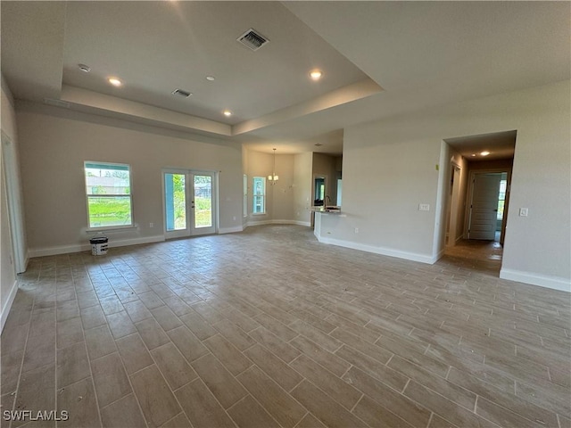 106 SE 5th Ave, Cape Coral, FL 33990 - unfurnished living room featuring a raised ceiling, baseboards, recessed lighting, and wood finished floors