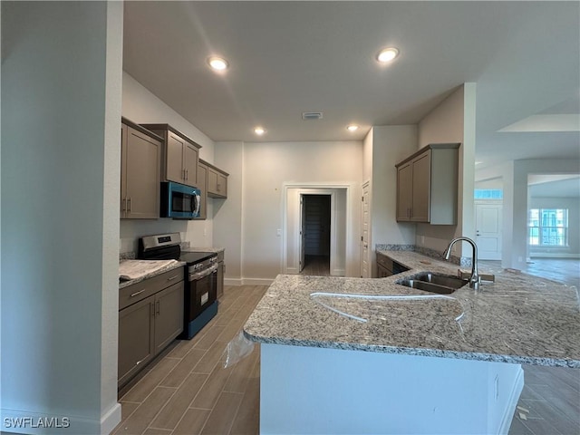 106 SE 5th Ave, Cape Coral, FL 33990 - kitchen with stainless steel appliances, a sink, gray cabinetry, a peninsula, and recessed lighting