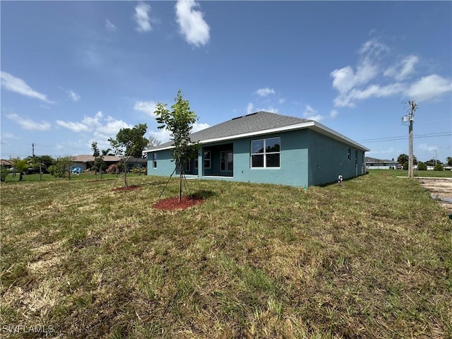 106 SE 5th Ave, Cape Coral, FL 33990 - rear view of house featuring a yard and stucco siding