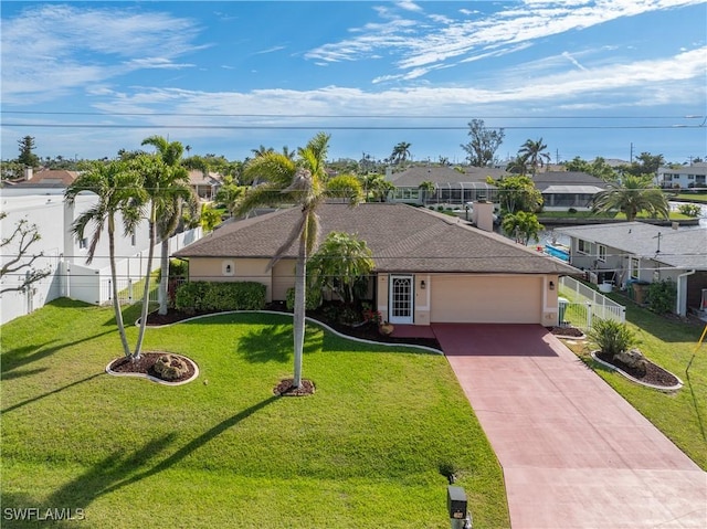 single story home featuring a garage, fence, driveway, a residential view, and a front lawn