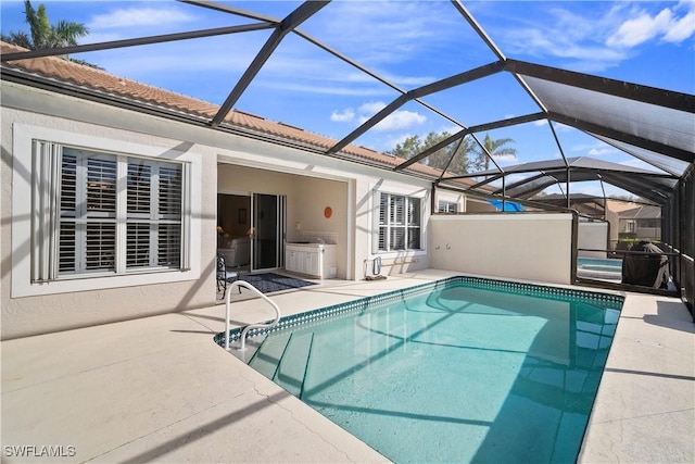 pool featuring glass enclosure and a patio area