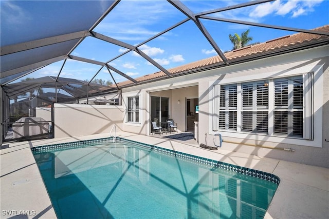 outdoor pool with a lanai and a patio area