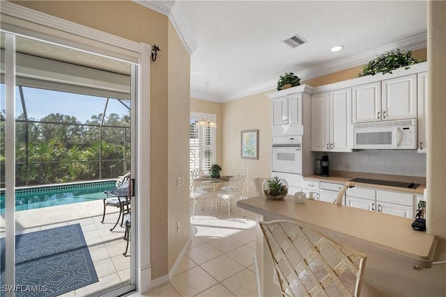 kitchen with white appliances, light tile patterned floors, visible vents, crown molding, and white cabinetry