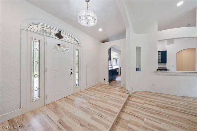 1240 Desoto Blvd S, Naples, FL 34117 - foyer entrance featuring arched walkways, wood finished floors, and a chandelier
