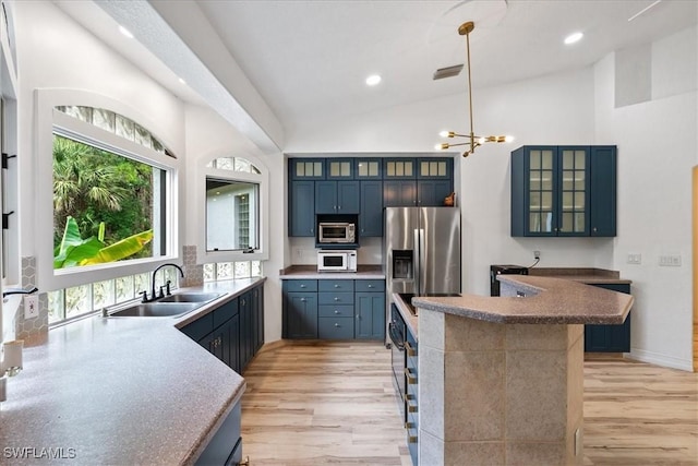 1240 Desoto Blvd S, Naples, FL 34117 - kitchen with appliances with stainless steel finishes, light wood-style flooring, recessed lighting, pendant lighting, and glass insert cabinets