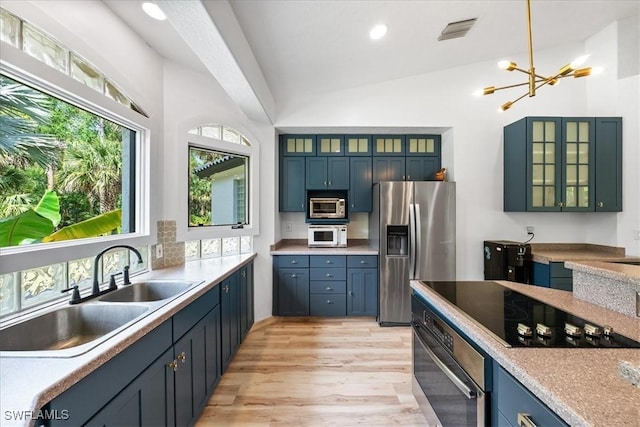 1240 Desoto Blvd S, Naples, FL 34117 - kitchen with appliances with stainless steel finishes, vaulted ceiling, a chandelier, light wood-style flooring, and light countertops