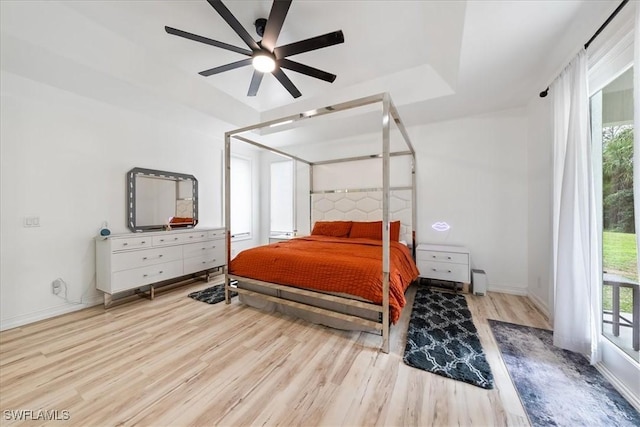 1240 Desoto Blvd S, Naples, FL 34117 - bedroom featuring wood finished floors, access to outside, a ceiling fan, and a tray ceiling