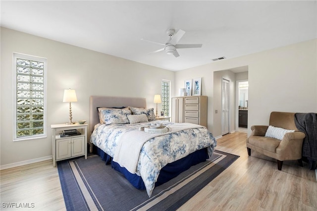 bedroom featuring light wood-style floors, visible vents, baseboards, and a ceiling fan