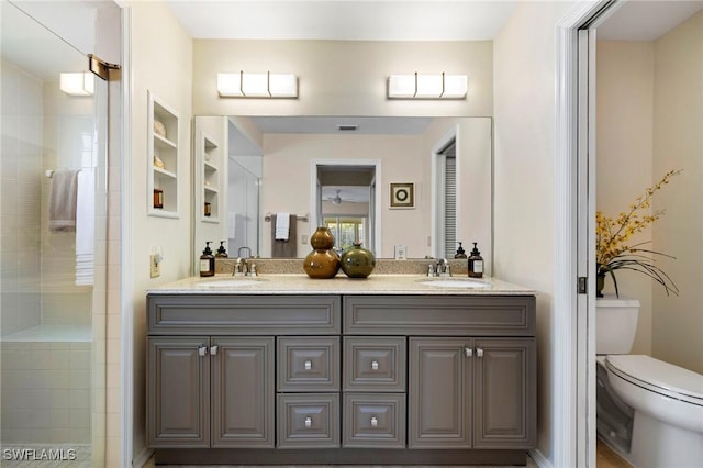 full bathroom featuring tiled shower, a sink, toilet, and double vanity