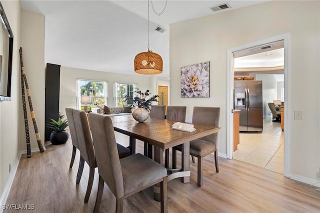 dining space featuring light wood-type flooring, baseboards, and visible vents