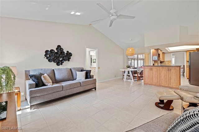 living area featuring vaulted ceiling, light tile patterned flooring, a ceiling fan, and baseboards