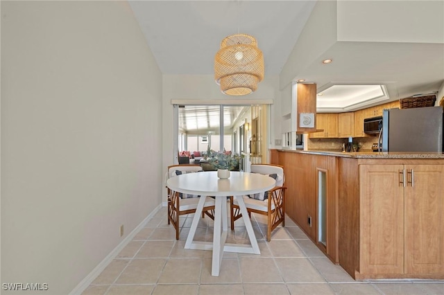 dining area with a tray ceiling, light tile patterned flooring, recessed lighting, and baseboards