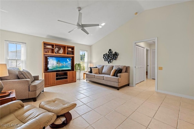 living area with light tile patterned floors, vaulted ceiling, a ceiling fan, and a healthy amount of sunlight