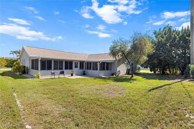 rear view of house with a sunroom and a yard