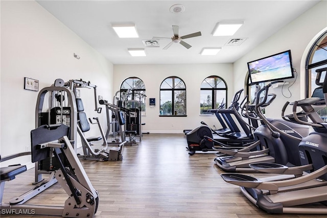 gym featuring a ceiling fan, baseboards, visible vents, and wood finished floors