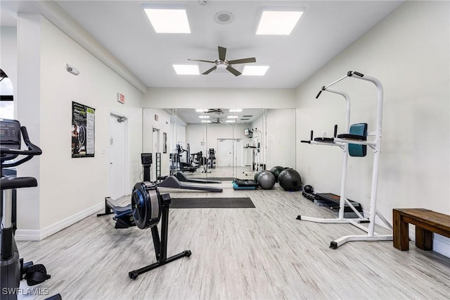 workout room featuring a ceiling fan, baseboards, and wood finished floors