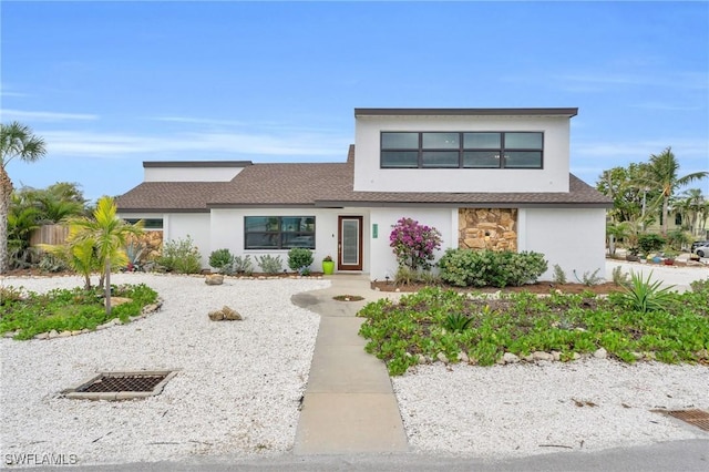 8080 Lagoon Rd, Fort Myers Beach, FL 33931 - view of front facade with stucco siding, stone siding, and roof with shingles