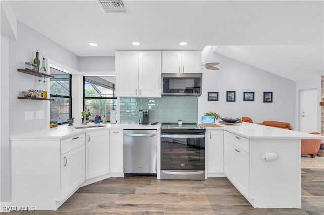 8080 Lagoon Rd, Fort Myers Beach, FL 33931 - kitchen featuring stainless steel appliances, a peninsula, a sink, light countertops, and recessed lighting