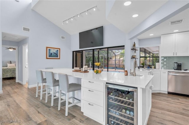 8080 Lagoon Rd, Fort Myers Beach, FL 33931 - indoor wet bar featuring beverage cooler, dishwasher, high vaulted ceiling, track lighting, and light wood-style floors