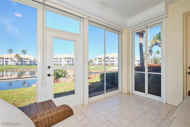 sunroom / solarium with a water view and visible vents