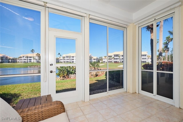 sunroom with a water view and a residential view