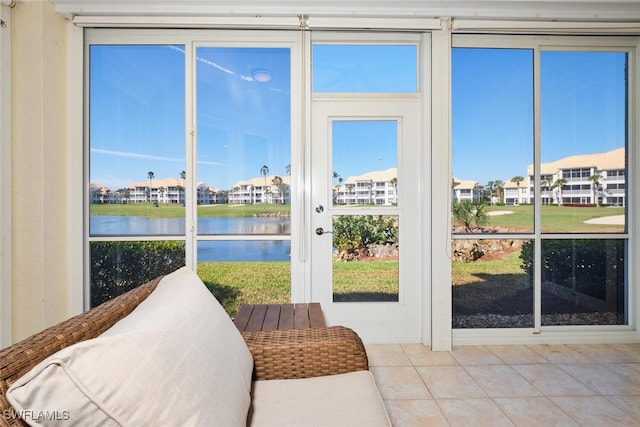 sunroom with a water view, a healthy amount of sunlight, and a residential view