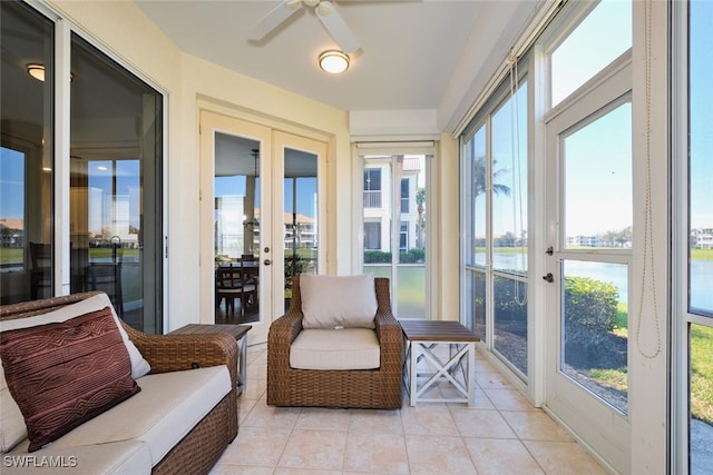 sunroom / solarium with a water view and a ceiling fan