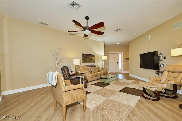 living area featuring visible vents, light wood-style flooring, and baseboards