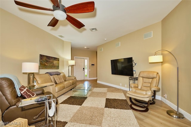 living area with light wood-style flooring, visible vents, and baseboards