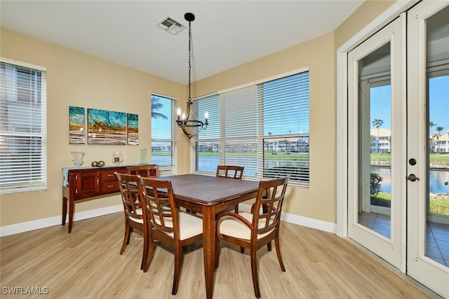 dining space with light wood finished floors, visible vents, and a wealth of natural light