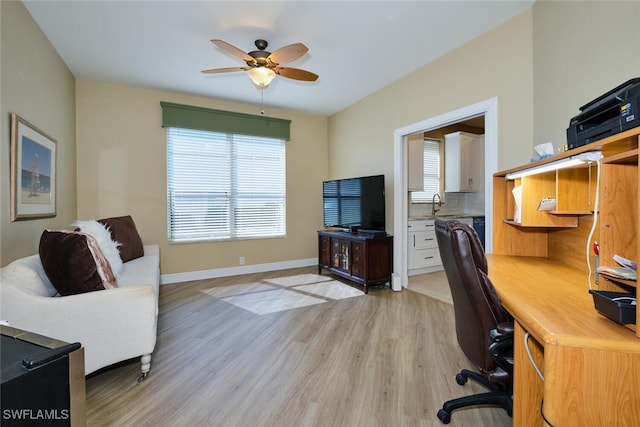 office space featuring ceiling fan, light wood-type flooring, and baseboards