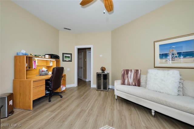 office space featuring light wood-style floors, baseboards, visible vents, and a ceiling fan