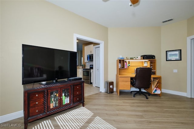 office area featuring light wood-type flooring, baseboards, visible vents, and a ceiling fan