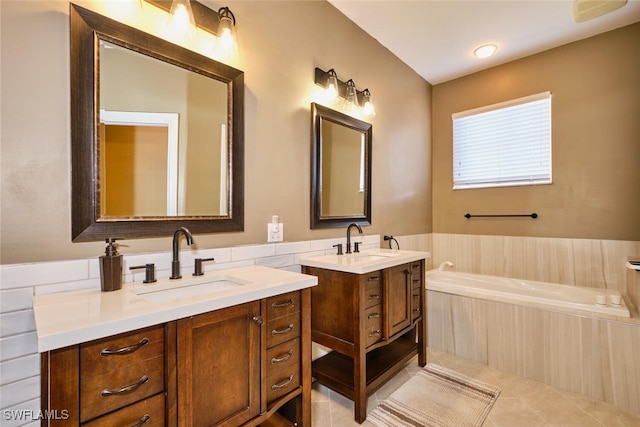 bathroom featuring tile patterned flooring, two vanities, a sink, and a garden tub