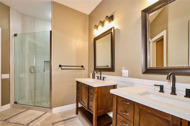 full bath with a stall shower, two vanities, a sink, and tile patterned floors