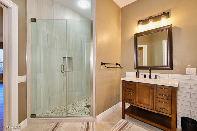 full bathroom with baseboards, tile patterned flooring, vanity, and a shower stall