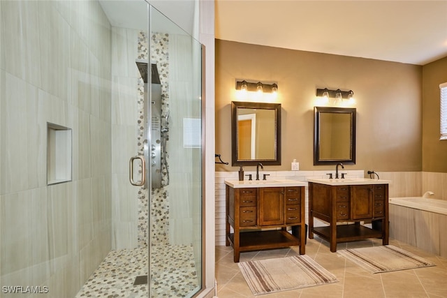 full bathroom featuring a sink, two vanities, wainscoting, tile patterned floors, and a stall shower