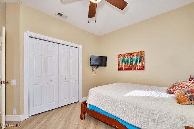 bedroom featuring light wood-style floors, baseboards, visible vents, and a closet