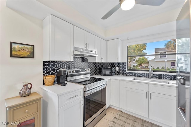 kitchen with under cabinet range hood, a sink, white cabinetry, stainless steel range with electric cooktop, and light countertops