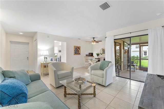 living room with a ceiling fan, visible vents, and light tile patterned floors
