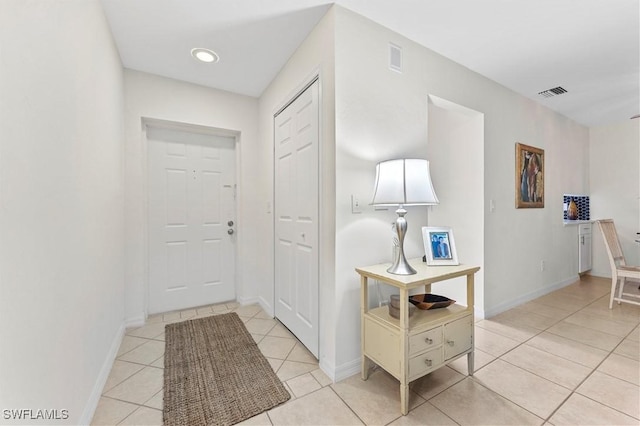 entryway with baseboards, visible vents, and light tile patterned flooring