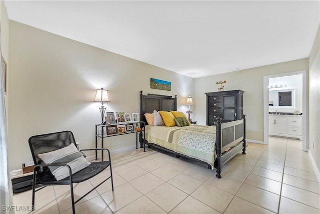 bedroom featuring baseboards, ensuite bath, and light tile patterned flooring