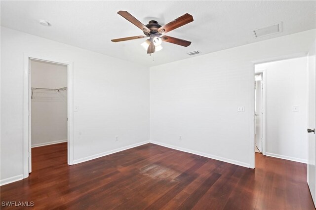 6451 Scott Ln, Fort Myers, FL 33966 - unfurnished bedroom with ceiling fan, wood finished floors, visible vents, baseboards, and a walk in closet