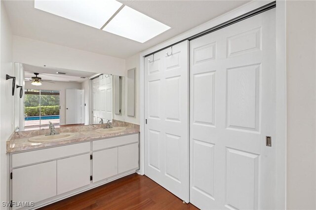 6451 Scott Ln, Fort Myers, FL 33966 - bathroom with double vanity, wood finished floors, a skylight, and a sink