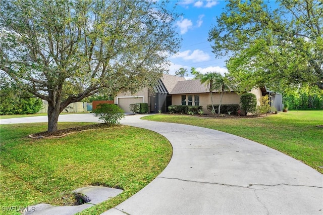 view of front of property featuring concrete driveway, a front lawn, and stucco siding