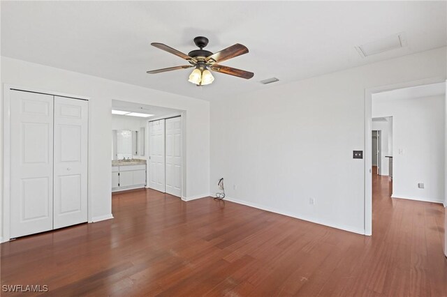 6451 Scott Ln, Fort Myers, FL 33966 - unfurnished bedroom featuring dark wood-style flooring, two closets, visible vents, and baseboards