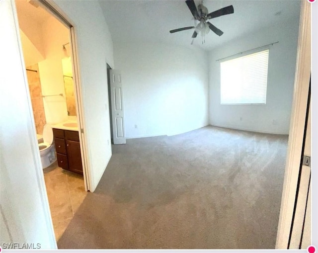 unfurnished bedroom featuring ensuite bath and light colored carpet