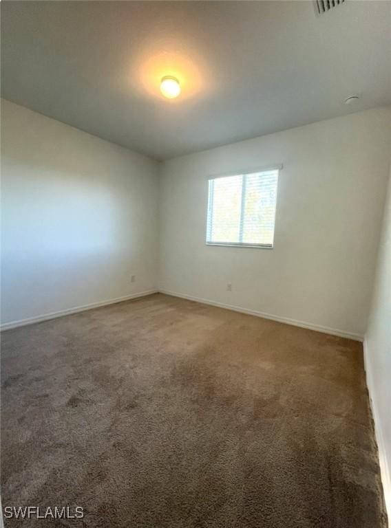 unfurnished room with baseboards and carpet flooring