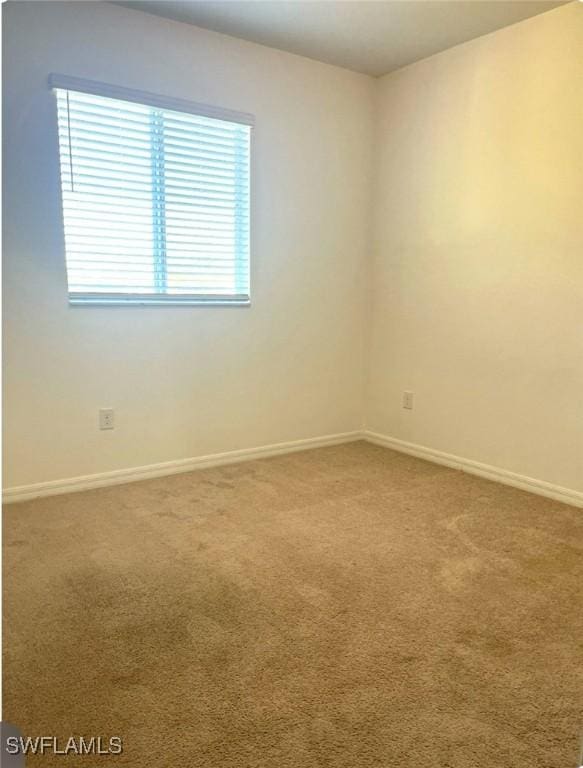 carpeted empty room with baseboards