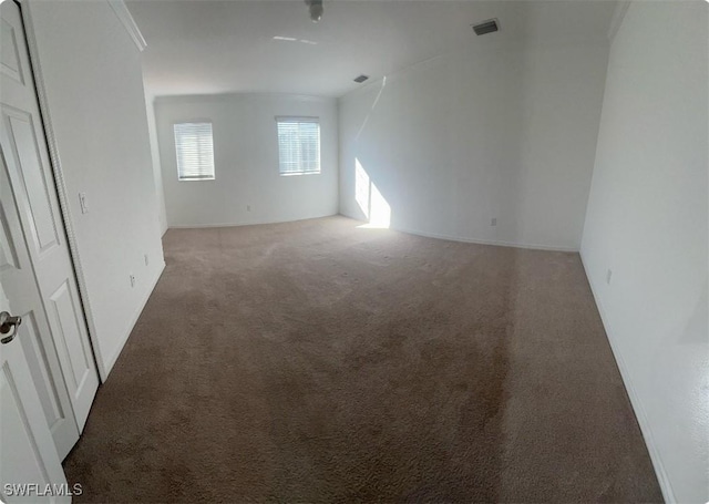 carpeted spare room featuring visible vents